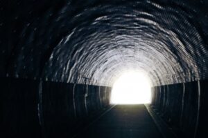暗闇のトンネルからみえる光り輝く出口